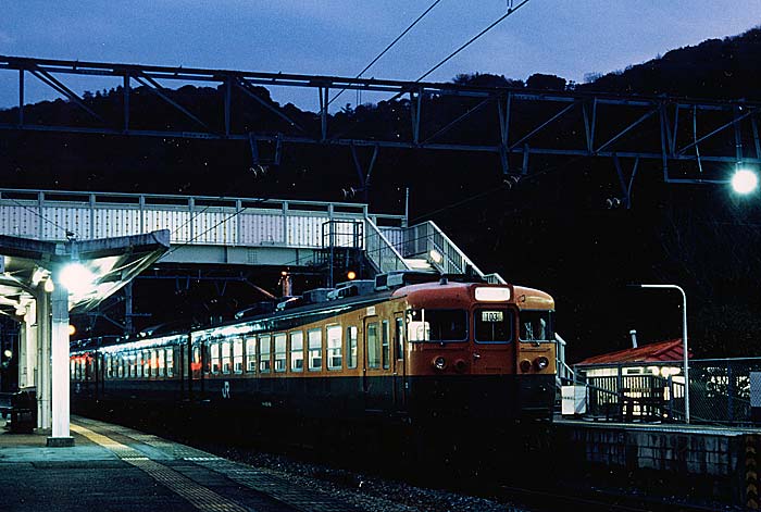 夕暮れの椿駅に停車中の165系普通列車